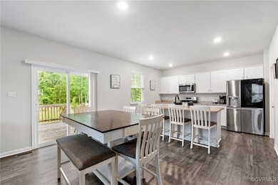 Dining area with dark wood-style flooring, recesse