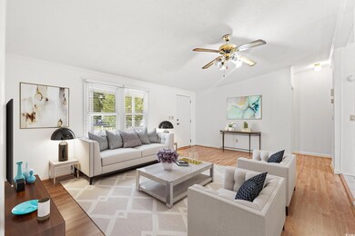 Living room with ceiling fan and light hardwood / 
