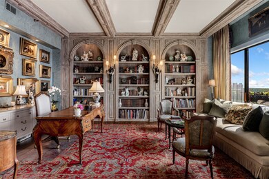 Office area featuring beam ceiling, built in features, and crown molding
