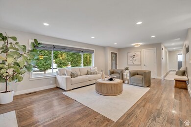 Living room with recessed lighting, light wood-type flooring, and plenty of natural light