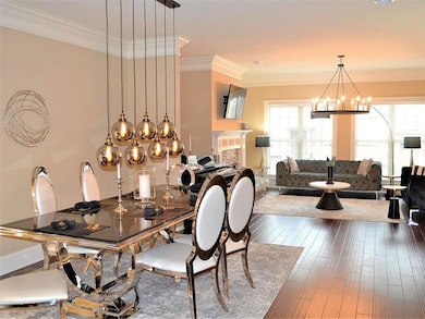 Dining area featuring crown molding, a fireplace, an inviting chandelier, and wood-type flooring