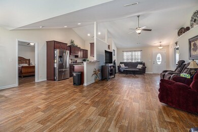 Living area featuring wood finished floors, ceiling fan, baseboards, high vaulted ceiling, and recessed lighting