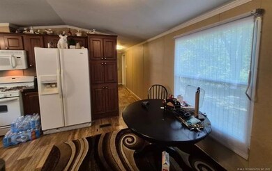 Kitchen featuring white appliances, light wood-style flooring, lofted ceiling, and crown molding