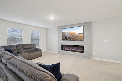 Carpeted living room featuring a large fireplace