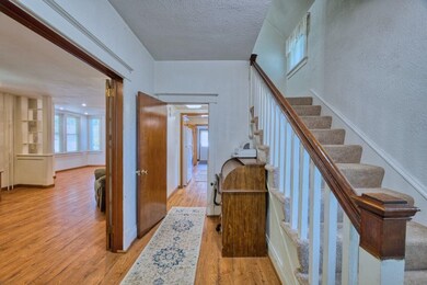 Stairway featuring wood finished floors, a textured ceiling, and a textured wall