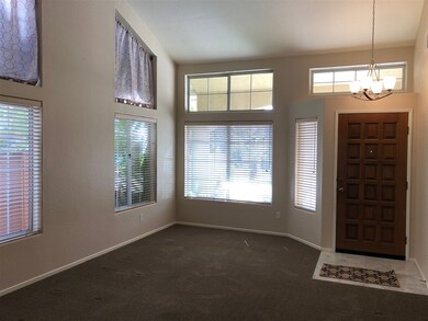 Living room and entry area with vaulted ceilings.