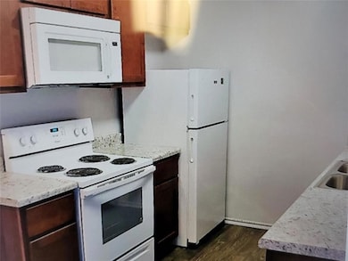 Kitchen with dark wood finished floors, white appl
