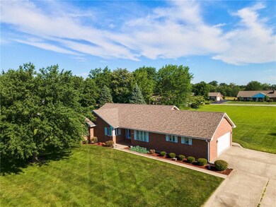 Ranch-style home with a garage, a front yard, driveway, and brick siding