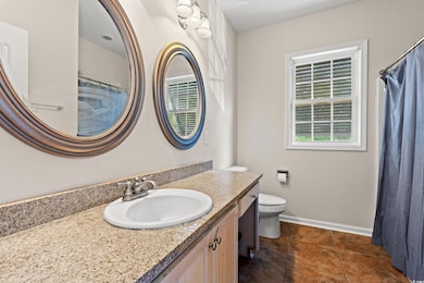 Full bath featuring vanity, baseboards, and toilet