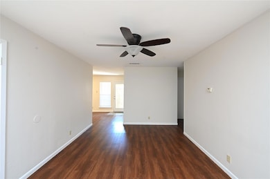 Empty room featuring dark wood-style flooring, ba
