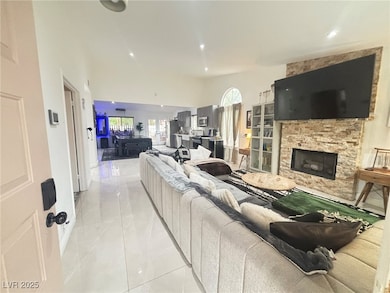 Living room featuring marble finish floor, a vault