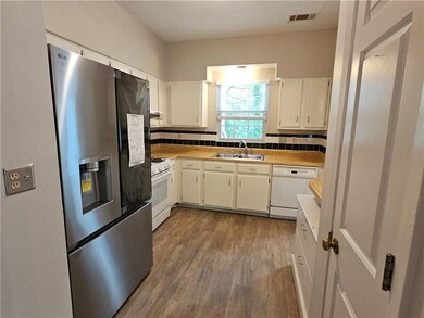 Kitchen with white appliances, a sink, wood finish