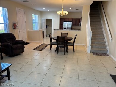 Tiled dining area featuring an inviting chandelier