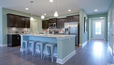 Kitchen featuring stainless steel appliances, dark brown cabinetry, baseboards, and recessed lighting