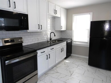 Kitchen featuring dark stone counters, white cabin