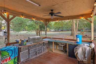 View of patio / terrace featuring an outdoor kitchen, a ceiling fan, and a deck