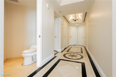 Hall with baseboards, visible vents, a tray ceilin