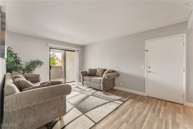 Living room with baseboards, a textured ceiling, a