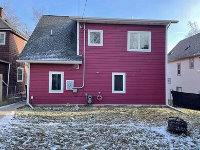 Snow covered rear of property with an outdoor fire