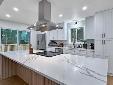 Chefs Kitchen with Oversized Island with Waterfall Quartz Countertops