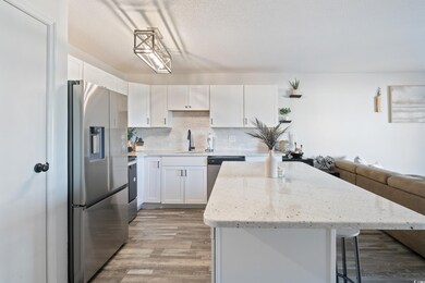 Kitchen with white cabinets, a center island, stai