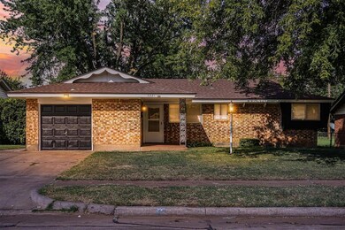 Single story home featuring a lawn and a garage