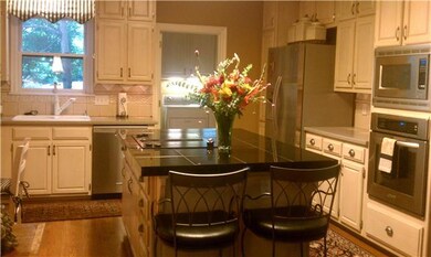 Laundry room is off kitchen (behind flowers), has tile floors, storage cabinets, built-in folding rack and a window for light! Located near garage with 2nd staircase to bonus room and secret access to master closet--Must see to understand! 