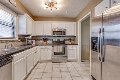 Kitchen has granite tile countertops, and stainles