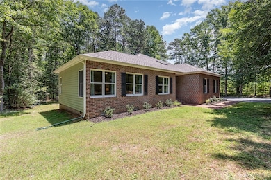 Brick front home set among shade trees on wooded h
