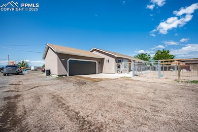 View of front of house featuring stucco siding, an attached garage, and a gate