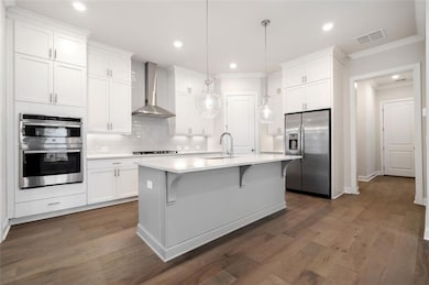 Kitchen with the upgraded cabinets to ceiling.  Upgraded appliance package, chimney style vent hood, gas cooktop, walk in pantry, quartz countertops and like-new refrigerator.