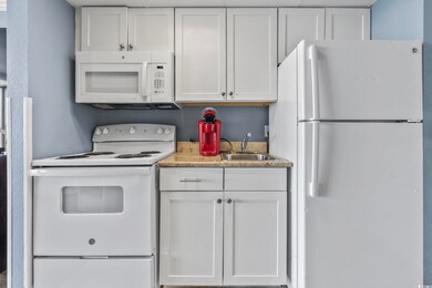 Kitchen featuring white appliances, white cabinetr