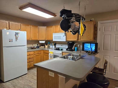 Kitchen with white appliances, light hardwood / wo