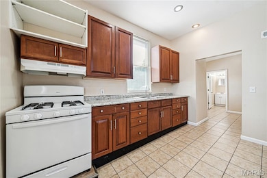 Kitchen featuring updated cabinets, recessed lighting and ceramic tile floor.