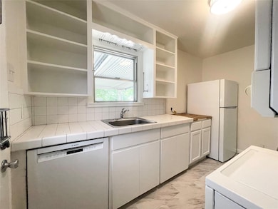 Kitchen with dishwasher, open shelves, light marb