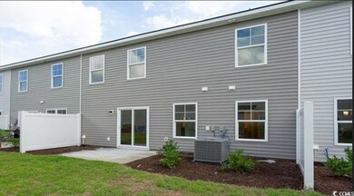 Rear view of house with a patio, a lawn, and centr