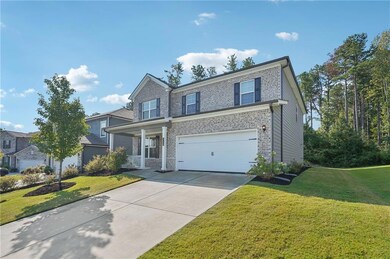 Traditional home featuring a porch, brick siding, driveway, and a front lawn