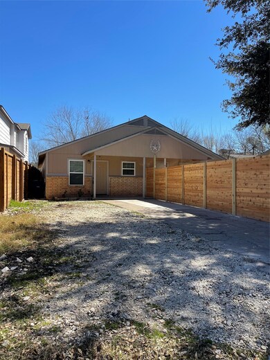 Back of house featuring fence, brick siding, and 