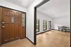 Entrance foyer with light wood-style flooring and vaulted ceiling