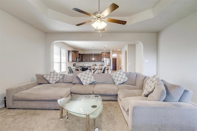 Living area featuring arched walkways, ceiling fan