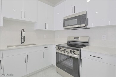 Kitchen featuring white cabinetry, stainless steel