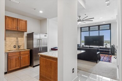 Kitchen featuring light stone counters, island, br