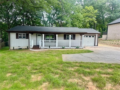 Ranch-style house with covered porch, an attached garage, concrete driveway, crawl space, and a front yard