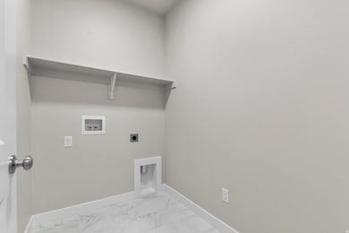 Laundry area with marble look tile flooring, hookup for an electric dryer, and hookup for a washing machine