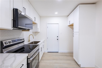 Kitchen with stainless steel appliances, a sink, l