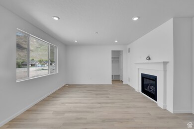 Unfurnished living room featuring a fireplace, recessed lighting, and light wood finished floors