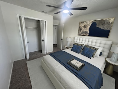 Bedroom featuring visible vents, a textured ceilin