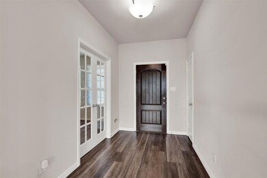 The door opens into a nice hallway with an office behind the French doors and a spacious closet across from it.