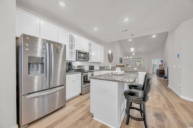 Kitchen with light wood-type flooring, appliances 