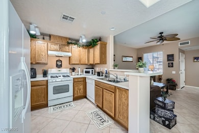 Kitchen with white appliances, light tile patterne